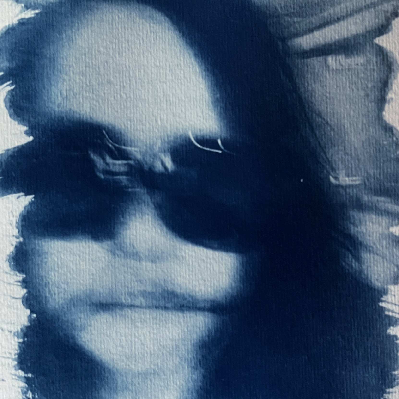 Selfie of the artist, very blurry, in cyanotype style, with blue tones.